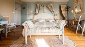 A bedroom with a large bed, a chair, a desk, and a mirror. - Chambres D'hotes La Barbinais Bed&breakfast St Malo (Saint-Malo)