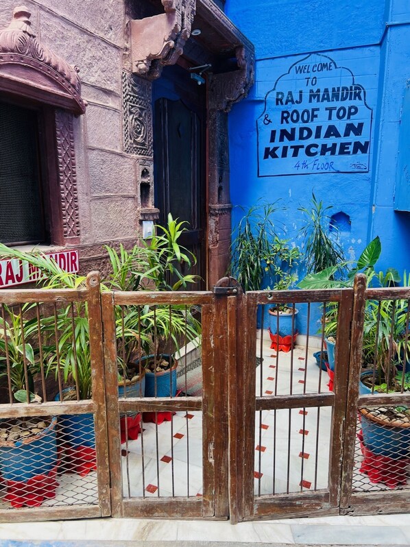 A traditional building with a sign welcoming to Raj Mandir Roof Top Indian Kitchen on the 4th floor. - The Raj Mandir (Jodhpur)