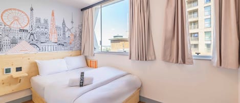 Een moderne hotelkamer met een groot bed, een houten hoofdbord, een muurschildering van een stadsgezicht, een raam met gordijnen en uitzicht op gebouwen.