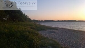 A beach with a sunset over the water.
