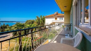 Un balcone con vista sul mare, una sedia e un tavolo.