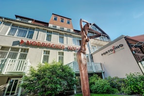 Ein Gebäude mit einem Schild für 'Nordischer Hof' und dem Restaurant 'Portofino'.