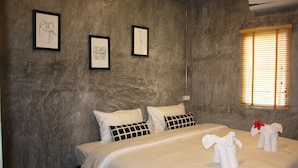 A hotel room with a large bed, two pillows, a framed picture on the wall, and a window with blinds. - The Simple Koh Yao Noi (Ko Yao)