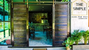 The entrance to a restaurant with a wooden facade and a sign reading "THE SIMPLE". - The Simple Koh Yao Noi (Ko Yao)
