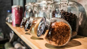 A row of glass jars with metal clasps, containing various items like coffee beans and brown sugar, on a wooden shelf. - The Simple Koh Yao Noi (Ko Yao)