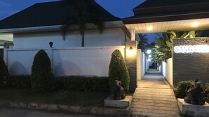 A modern building with a well-maintained lawn, a stone pathway leading to the entrance, and a sign that reads "SANGA". - Sanga Villas (Rawai)