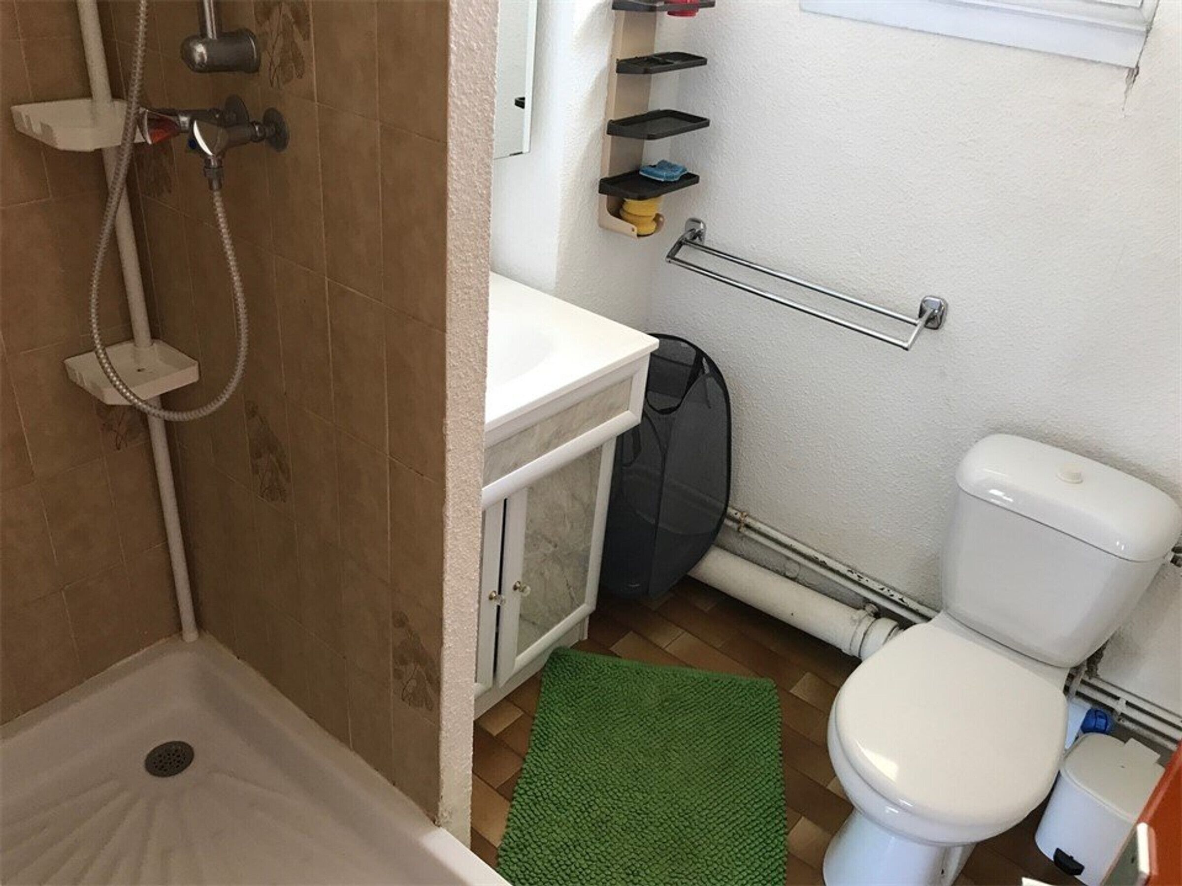 A bathroom with a shower, toilet, and sink.