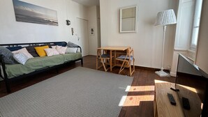 Une chambre avec un lit, un bureau, une lampe et un téléviseur.