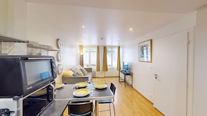 A compact kitchen with a microwave, stove, and dining area with a table set for two. - Tonnelier Strasbourgeois cathedrale city center (Strasbourg)