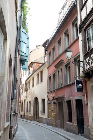 Une rue étroite bordée de bâtiments historiques, caractérisée par des portes en arc de cercle et une architecture traditionnelle.
