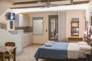 A bedroom with a bed, a television, a desk, and a chair.