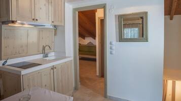 A kitchen with wooden cabinets, a sink, and a table with a glass.