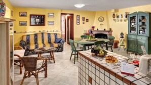 A cozy living room with a sofa, a dining table, and a fireplace. - Peter's House (Sorrento)