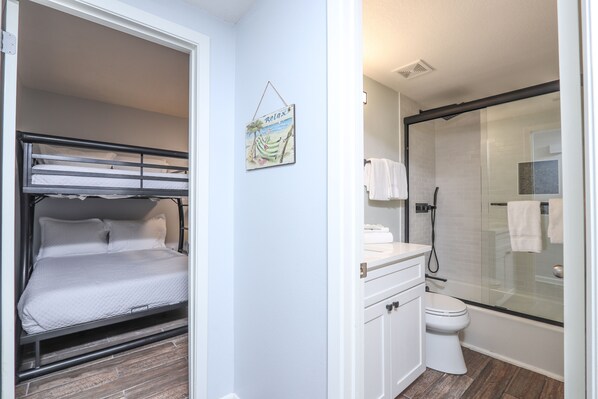 A compact room with a bunk bed, a small bathroom with a shower, and a toilet. - Phoenix X 604 by Liquid Life (Orange Beach)