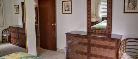 Un dormitorio con cama, cómoda y espejo.