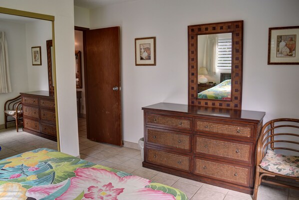Une chambre à coucher avec un lit, une commode et un miroir.