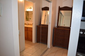 A bathroom with a wooden vanity, a mirror, and a sink. - Bright and Spacious Corner Studio Unit with Wrap Around Lanai (Kihei)