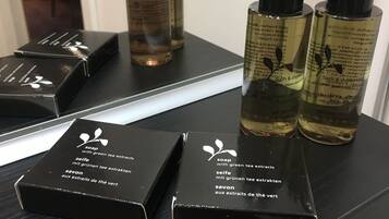 Ein Badezimmer-Schrank mit schwarzen Seifenschachteln und Flaschen mit Grüner Tee Extrakt Seife.