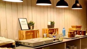 A room with wooden panel walls, a reception desk with a framed sign, and pendant lighting.