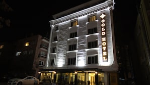 Um hotel com uma placa chamativa indicando "GOLD HOTEL" e um design arquitetônico clássico.