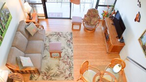 A spacious living area with a sofa, chairs, a small table, and a television. - Beautiful, Updated Condo Across the Street from Famous Charley Young Beach (Kihei)