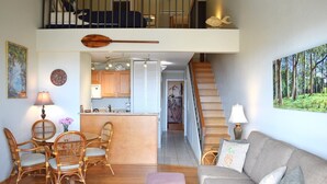 A spacious living area with a sofa, chairs, a dining table, and a kitchen in the background. - Beautiful, Updated Condo Across the Street from Famous Charley Young Beach (Kihei)