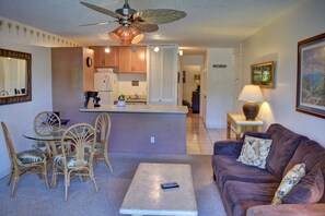 Cozy living space with a central kitchen area, dining table, and comfortable seating.