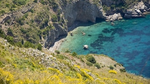A coastal landscape with rocky cliffs and clear turquoise water. - Campanella's Studios (Massa Lubrense)