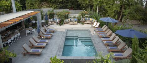 Outdoor pool, a waterfall pool, pool umbrellas, sun loungers