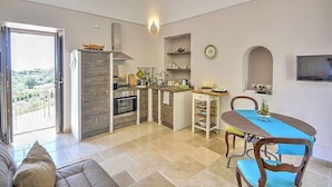 Una cocina moderna con comedor, sofá y vistas al exterior.