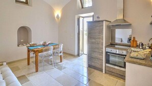 Una cocina moderna con horno empotrado y comedor con mesa y sillas.