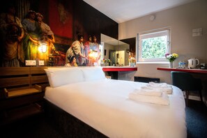 Relax in comfort with a large bed, a desk for work, and a mirror for getting ready.