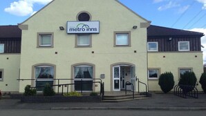 A two-story building with a sign reading "metro inns" at the entrance.