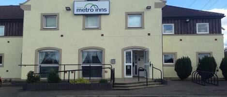 A two-story building with a sign reading "metro inns" at the entrance.