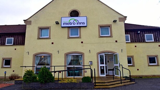 A building with a sign reading "metro inns" and a door labeled "metro velco".