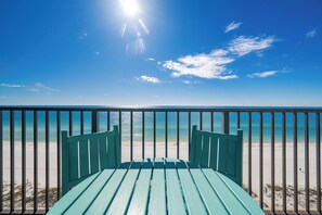 Vista desde un balcón con vista a una playa y cielo despejado.