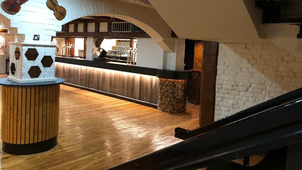 An interior with a wooden floor, a bar area with a counter, and a hanging violin. - Metro Inn Walsall (Walsall)