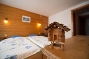 Ein Holzbett mit einem kleinen Holzmodell eines Hauses darauf.
