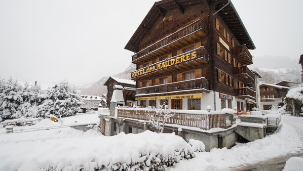 Ein Holzhaus mit Balkonen und einem Schild mit der Aufschrift 'Hotel des Hauderes'.