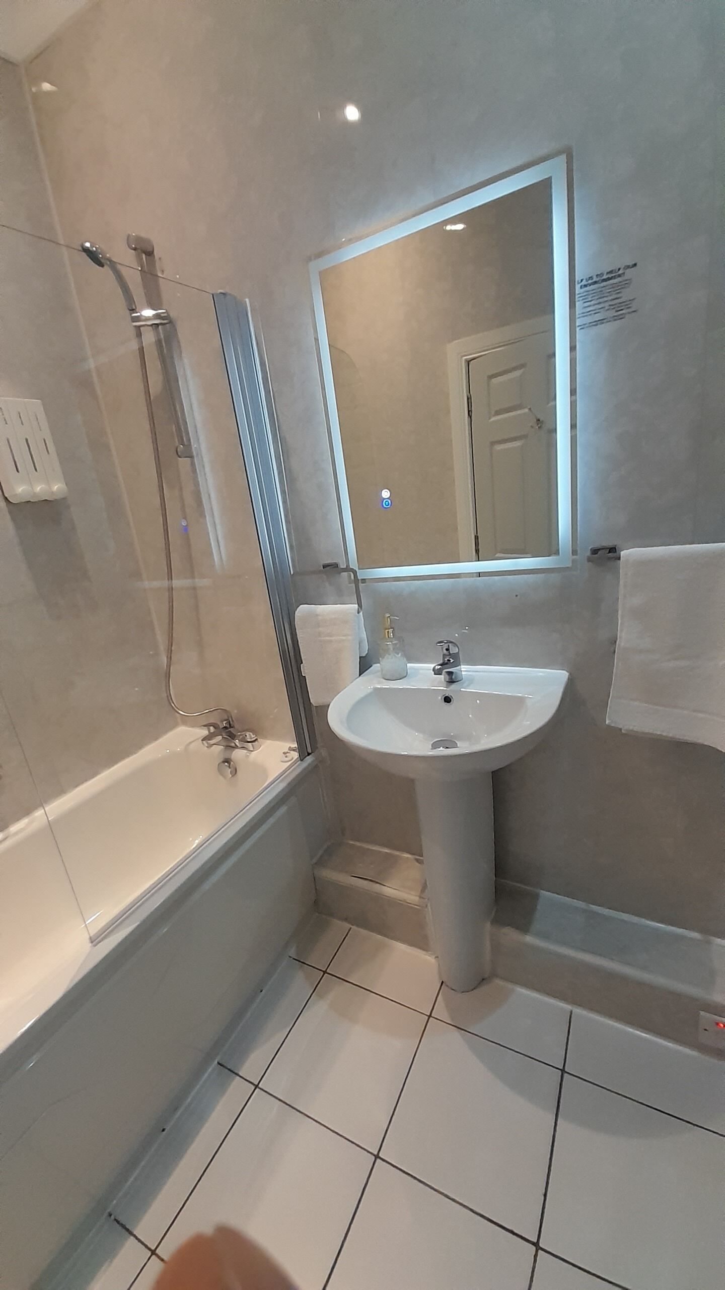 A modern bathroom with a bathtub, a sink, and a shower.