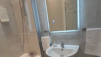 A modern bathroom with a bathtub, a sink, and a shower.