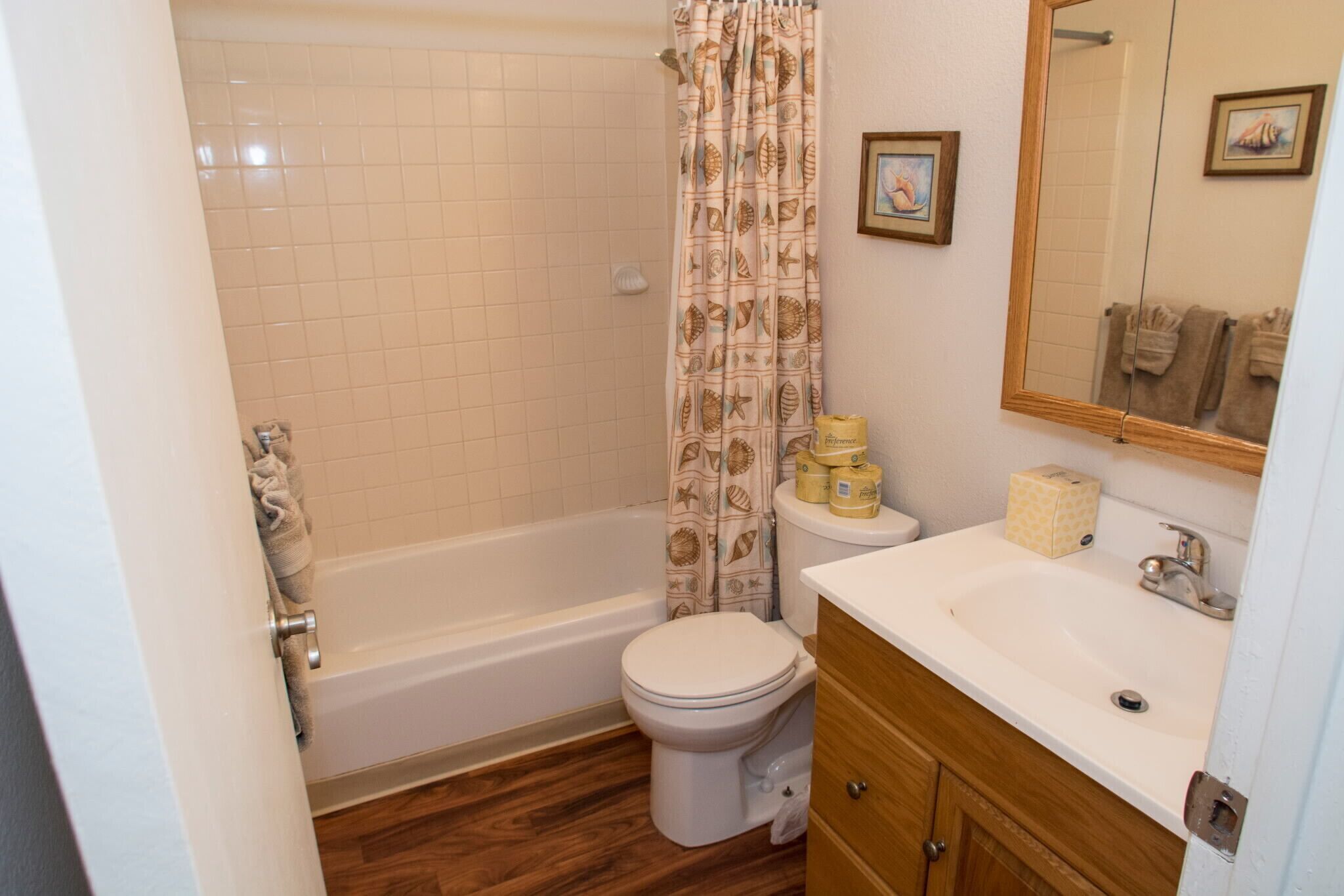 Une salle de bain avec une baignoire, des toilettes, un lavabo et des meubles en bois.