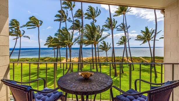 Ein Balkon mit Blick auf das Meer und Palmen.