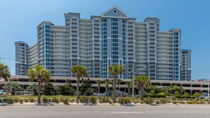 A multi-story hotel with a modern architectural design, featuring a central atrium and multiple balconies.