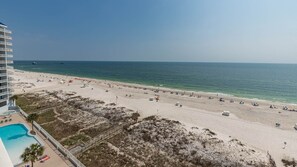 Una playa con piscina, sombrillas y sillas de playa.