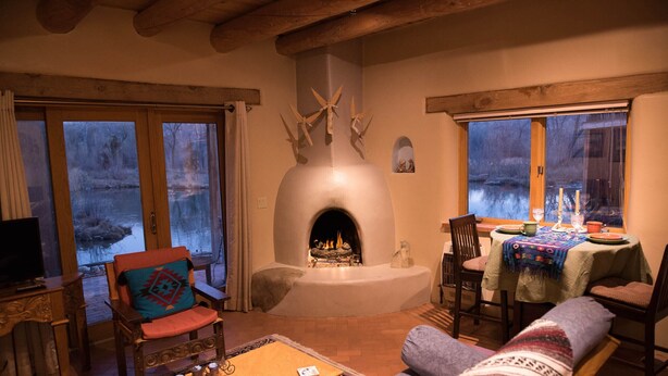 Una sala de estar acogedora con chimenea, muebles de madera y vistas al exterior.