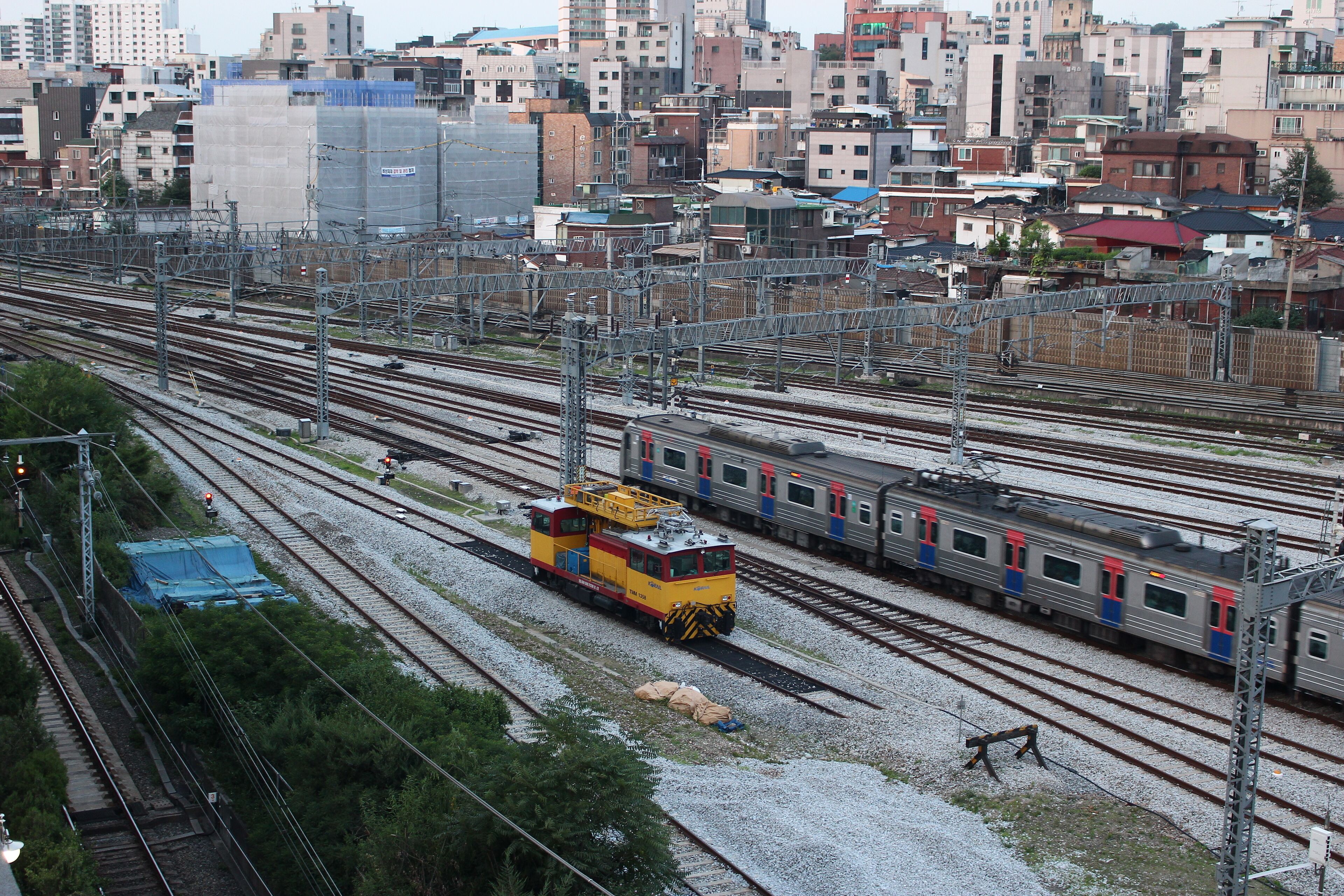 A train station with multiple tracks and a train on one of the tracks.