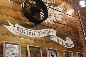 A wall with a wooden texture, a sign reading "Kustom Culture," and framed artwork. - 31 Page (Seoul)