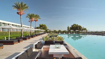 Ein Poolbereich mit Liegestühlen, einem Pool und Palmen.
