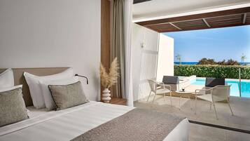 Una habitación de hotel moderna con cama, vista a la piscina y mobiliario exterior.